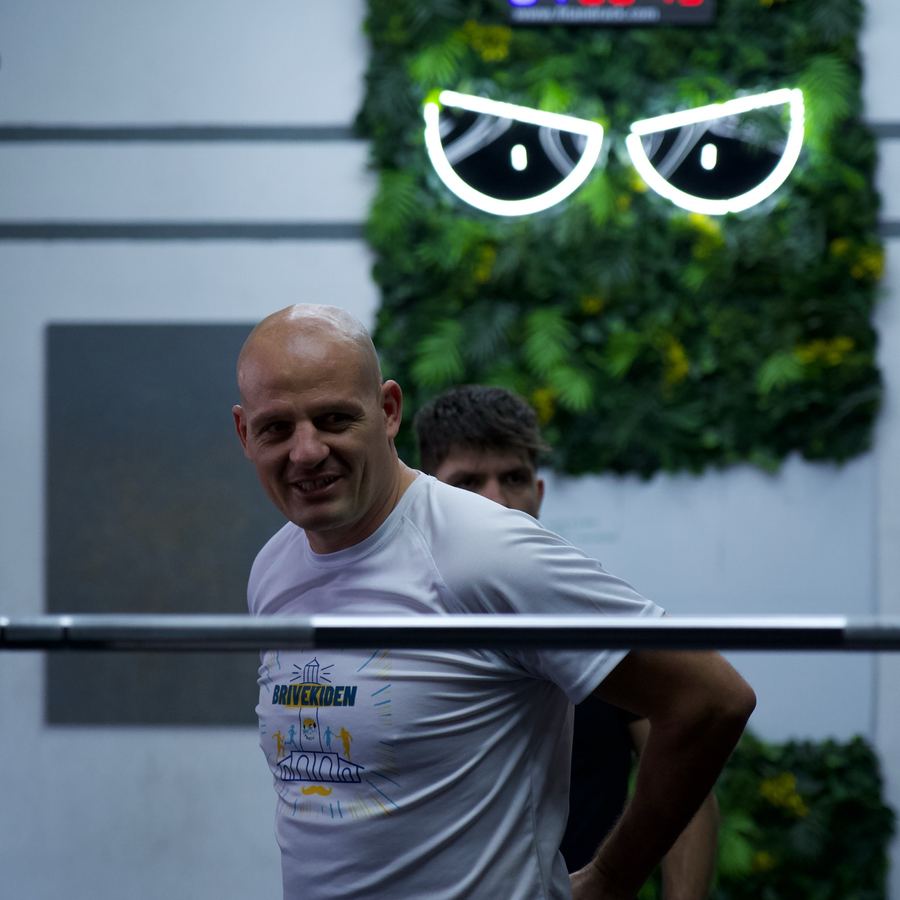 Adhérent souriant pendant le cours, devant le mur végétal de Devil Performance